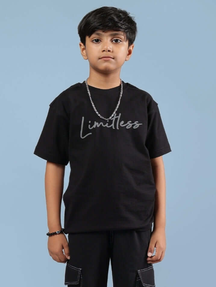 Child wearing a black "Limitless" t-shirt suitable for boys and girls, featuring a stylish design made by experienced tailors.