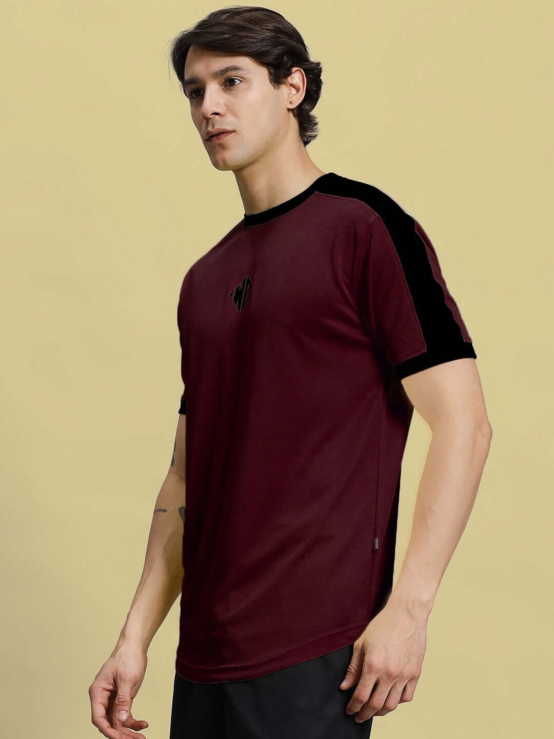 Man wearing maroon Sherpa regular fit T-shirt made of sports polyester fabric, showcasing side stripes and crew neck, ideal for casual wear.