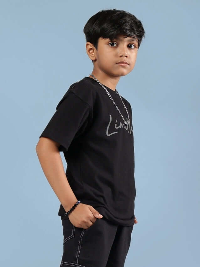 Young boy wearing a black "Limitless" t-shirt designed for boys and girls by DUDS, showcasing casual style with custom fit options.