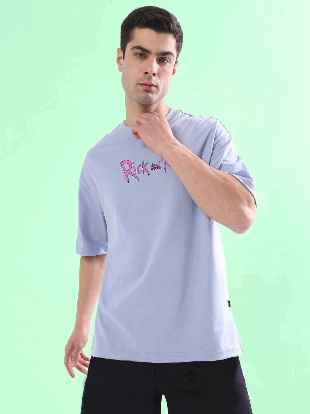 Model wearing BACK IN TIME OVER-SIZED T-SHIRT LILAC in 100% cotton, front view on a green background.