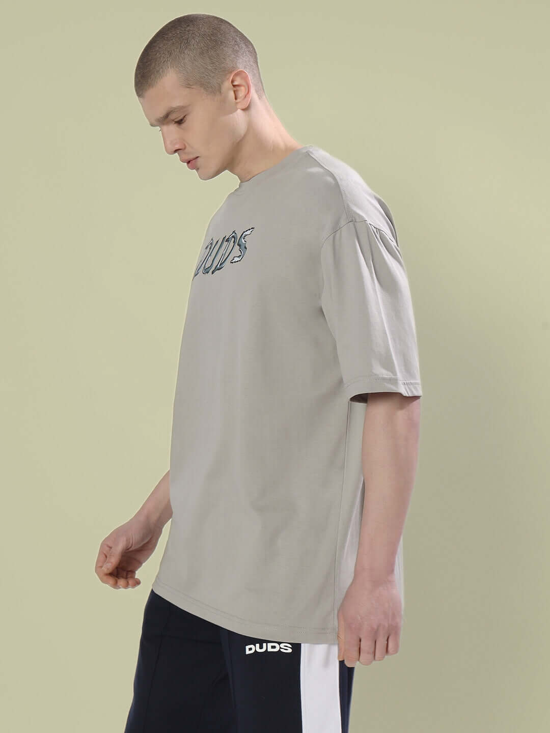 Male model wearing POSITIVE RABBIT OVER-SIZED T-SHIRT GREY made from 100% cotton premium heavy gauge fabric, side view.