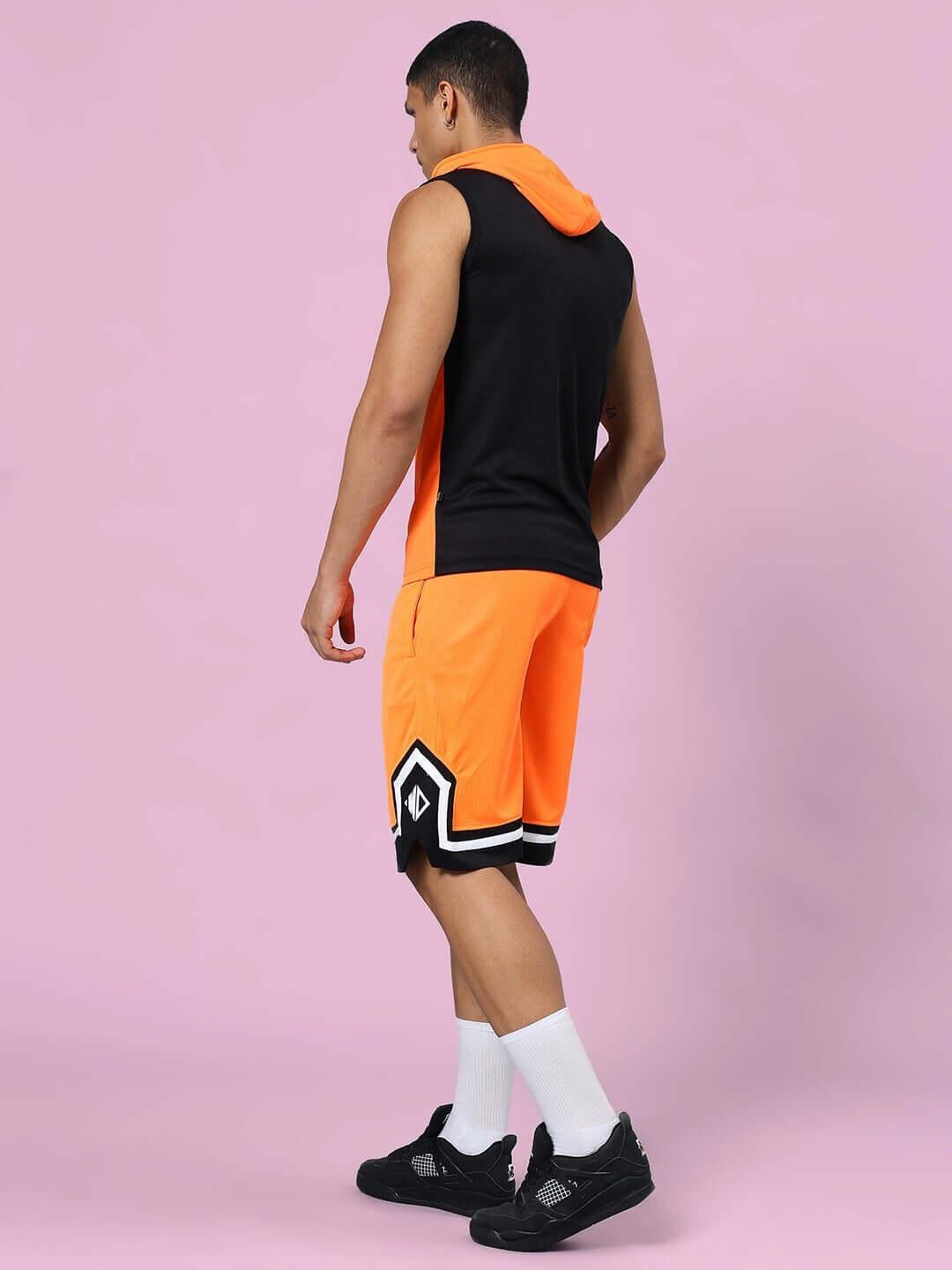 Man wearing Franky Gym Co-ord Set in orange and black, featuring a sleeveless hoodie and shorts. Polyester fabric, perfect for workouts.