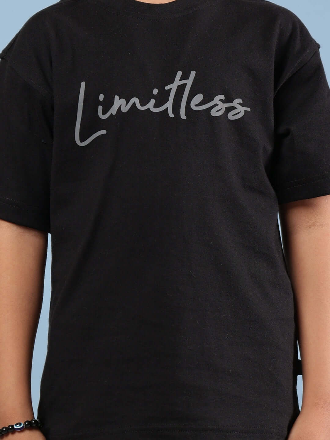 Child wearing a black Limitless T-shirt designed for boys and girls, showcasing minimalist style with custom fit option from DUDS.
