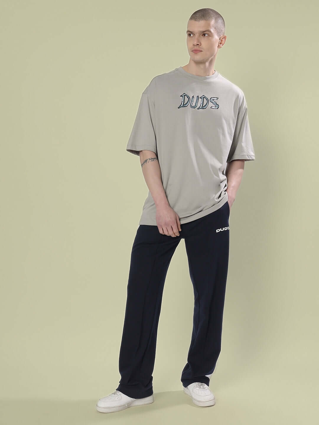 Model wearing POSITIVE RABBIT OVER-SIZED T-SHIRT GREY made from 100% cotton, paired with dark pants and white sneakers.