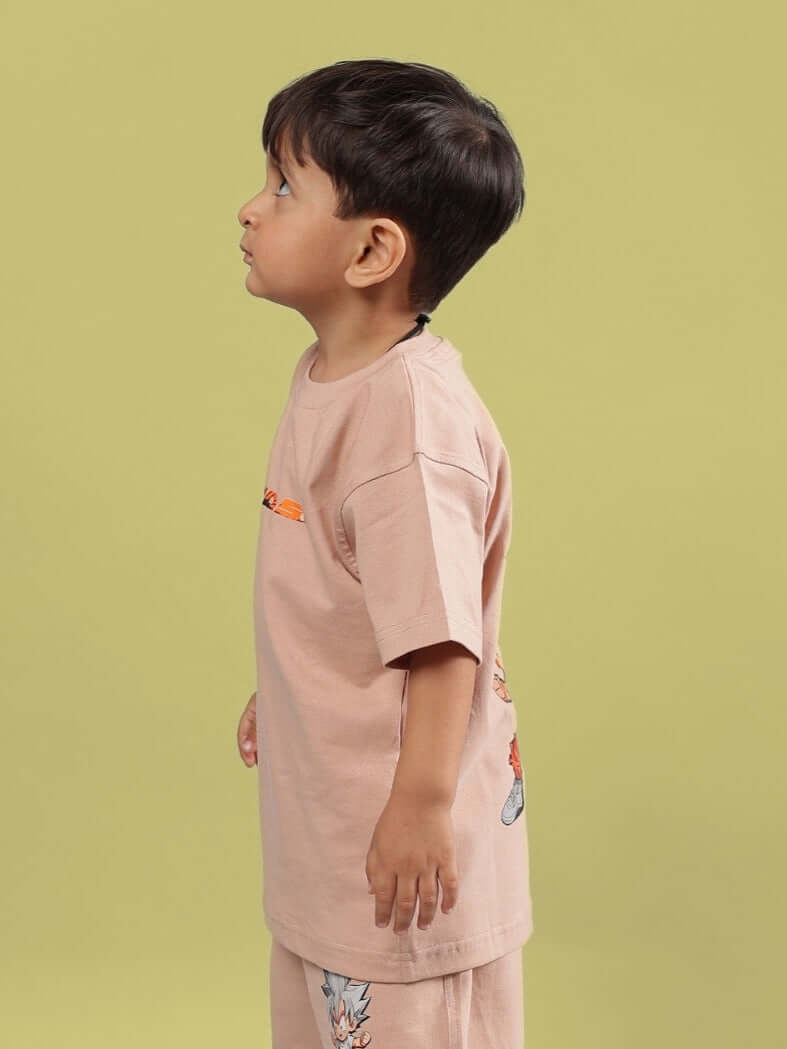 Child wearing a beige GOHAN T-shirt designed for boys and girls by DUDS, displaying side view with playful cartoon print.
