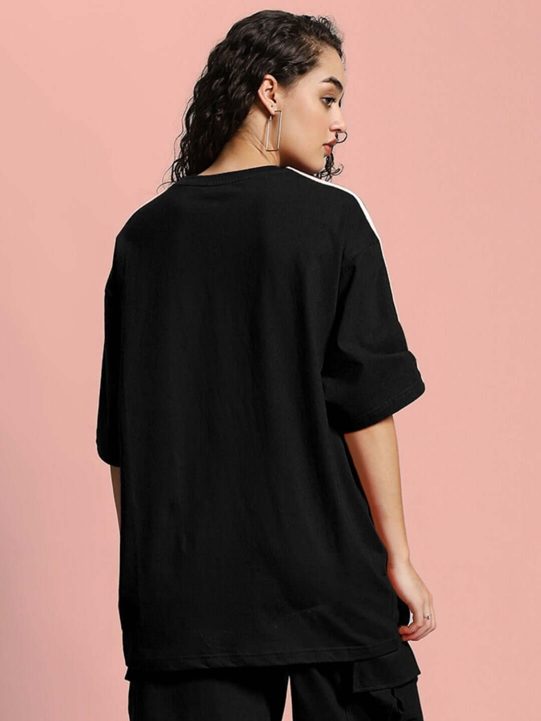 Back view of woman wearing oversized black Scotia T-shirt made from premium cotton French terry with rolled up sleeves.