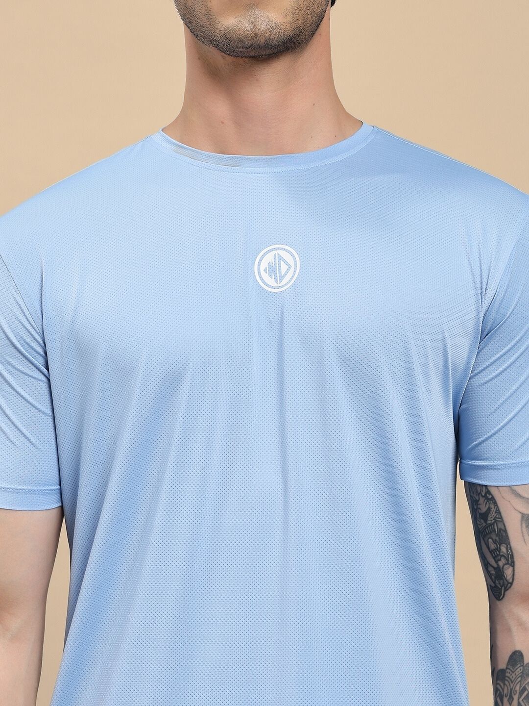 Light blue t-shirt with a logo on a beige background
