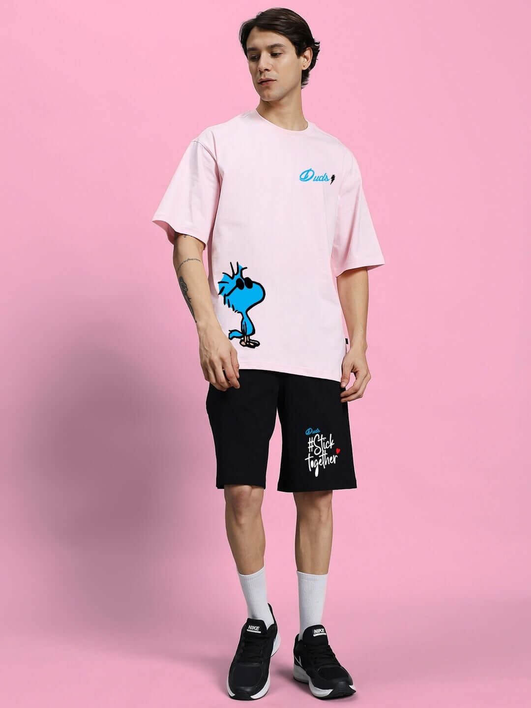 Model wearing COOL PALS Summer Co-Ord Set in pink and black featuring premium cotton fabric and playful graphic, perfect for summer style.