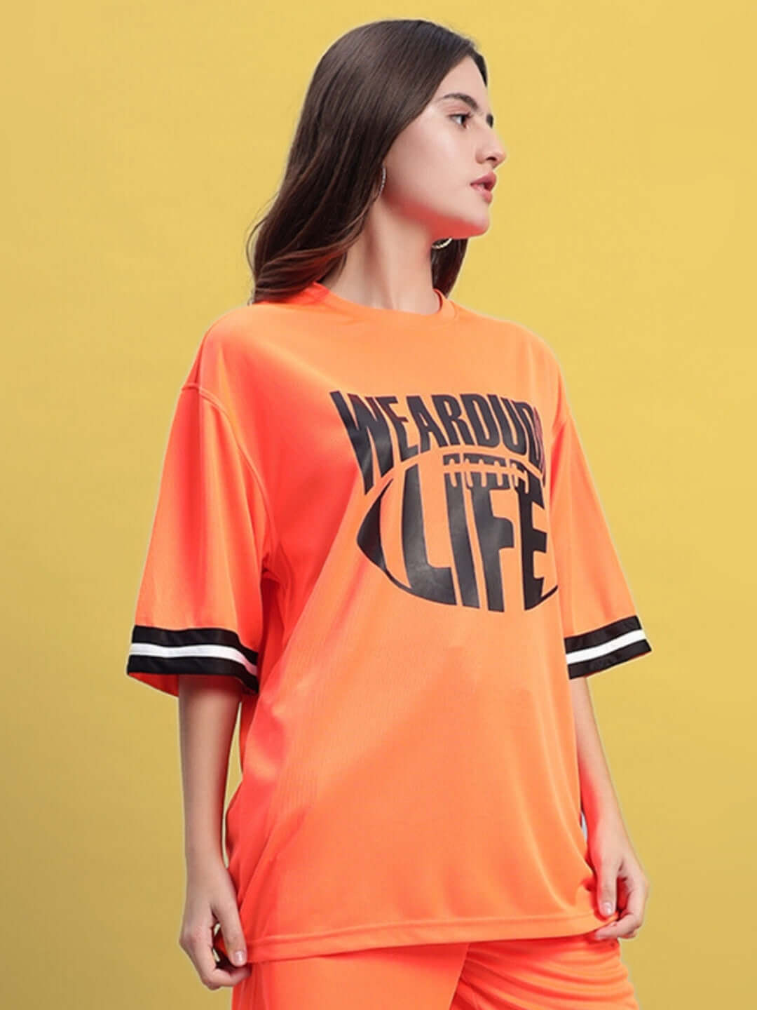 Woman wearing orange oversized T-shirt with 'Wearout Life' print, customizable size available, handmade quality.