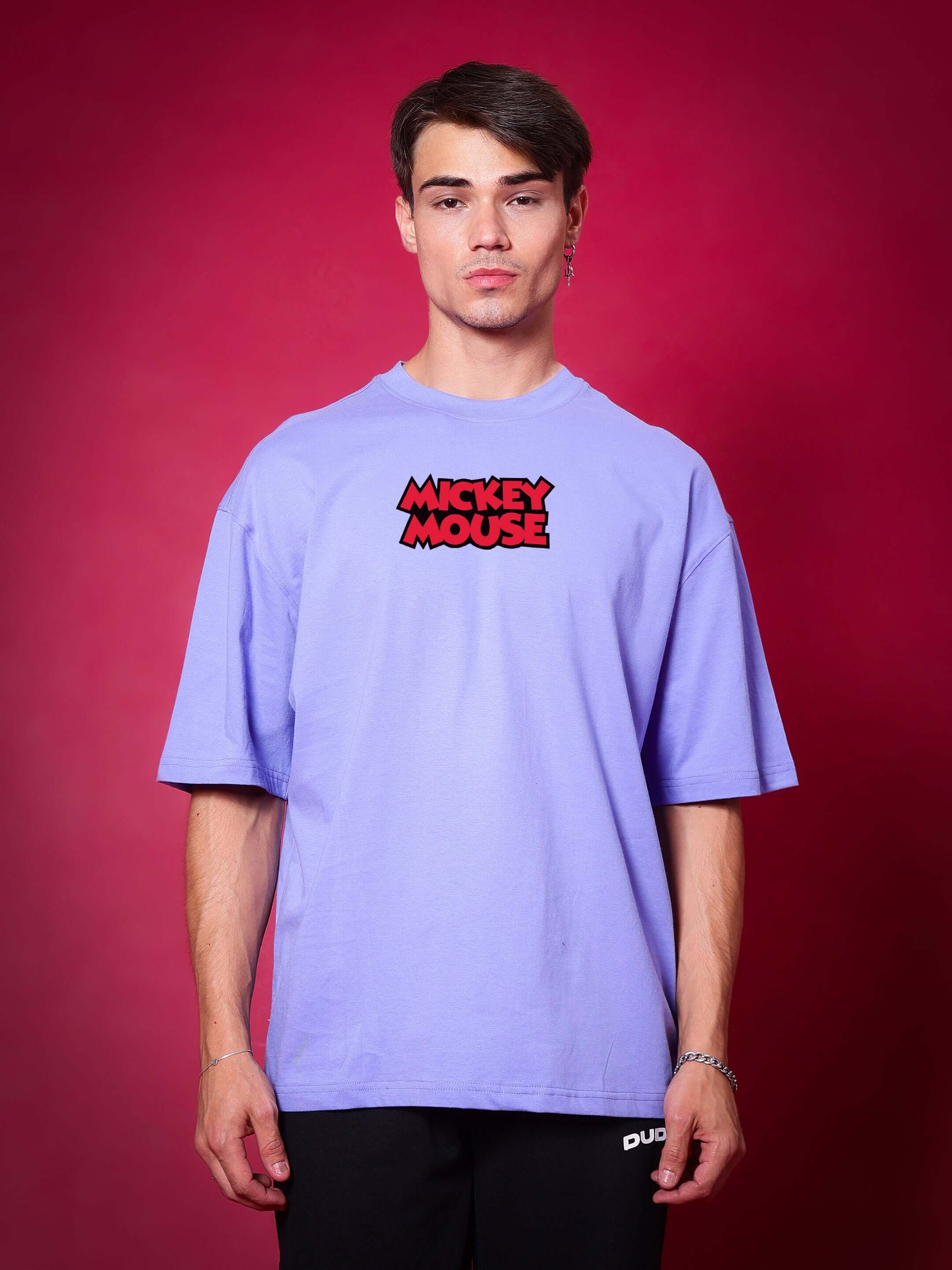 Person wearing DUDS MOUSE OVER-SIZED T-SHIRT PERIWINKLE with bold Mickey Mouse graphic, suitable for custom sizing options.
