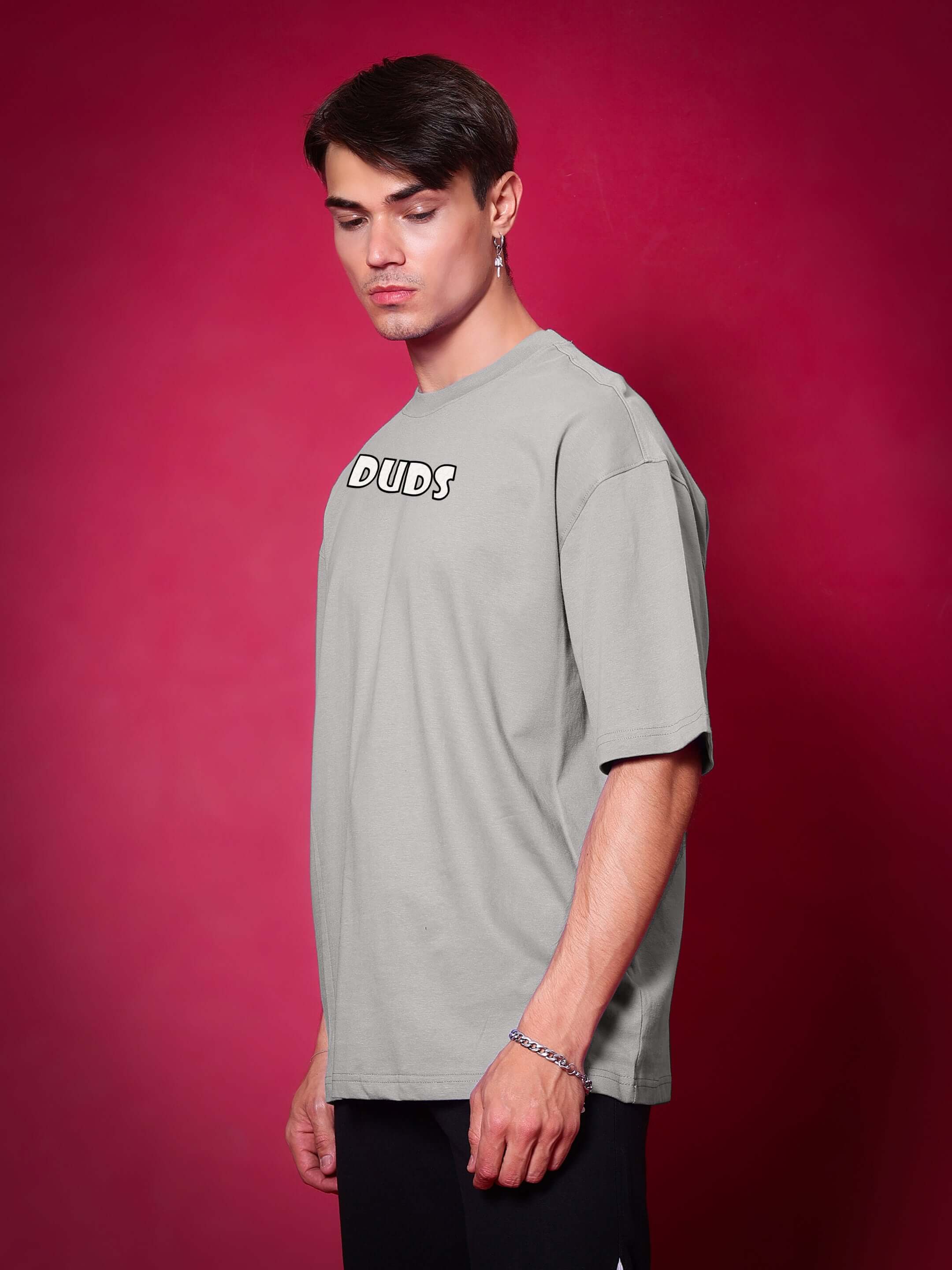 Model wearing WOLF PACK OVER-SIZED T-SHIRT GREY against red background