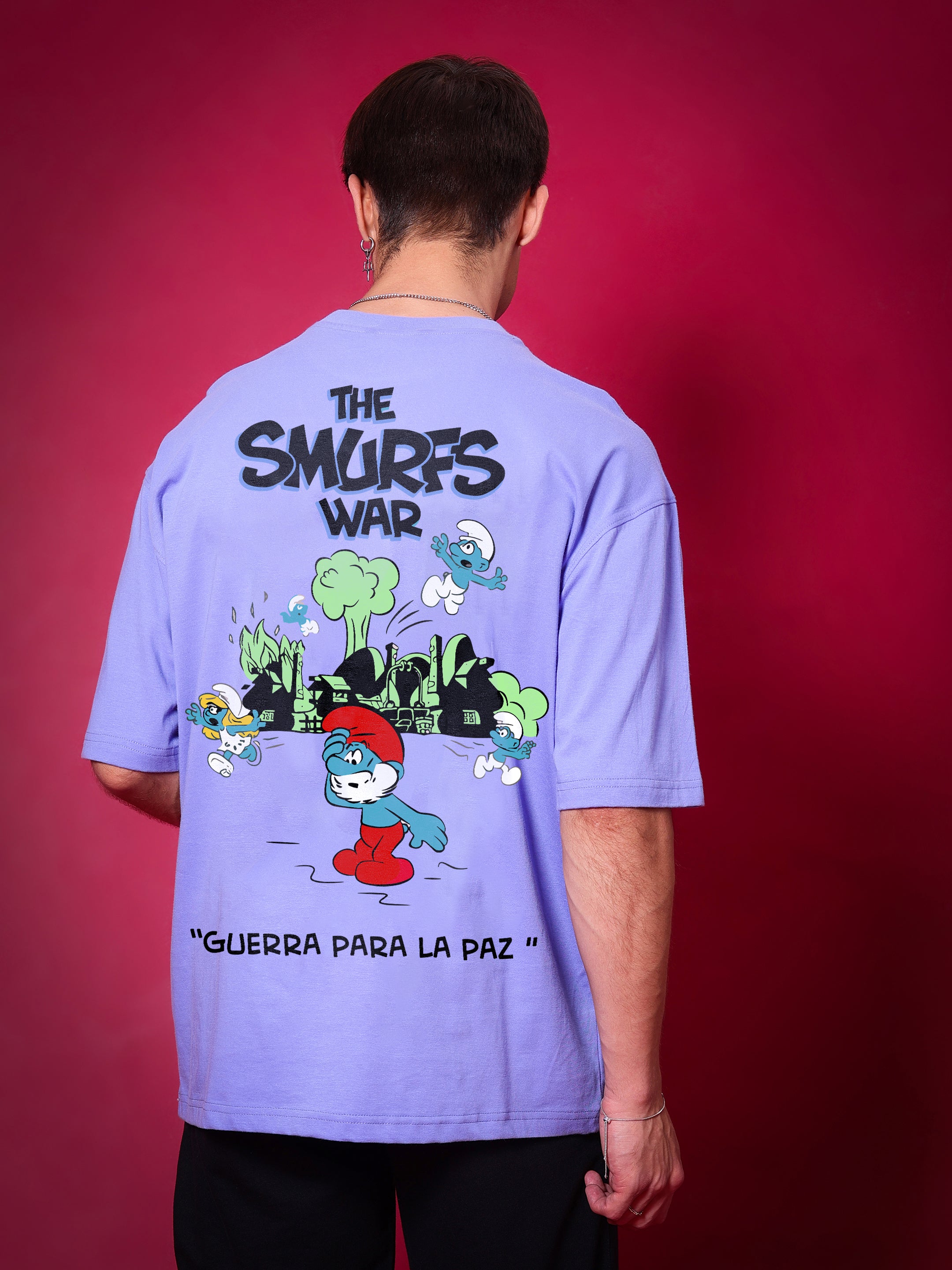 Man wearing SMURFS OVER-SIZED T-SHIRT PURPLE with cartoon print on red background