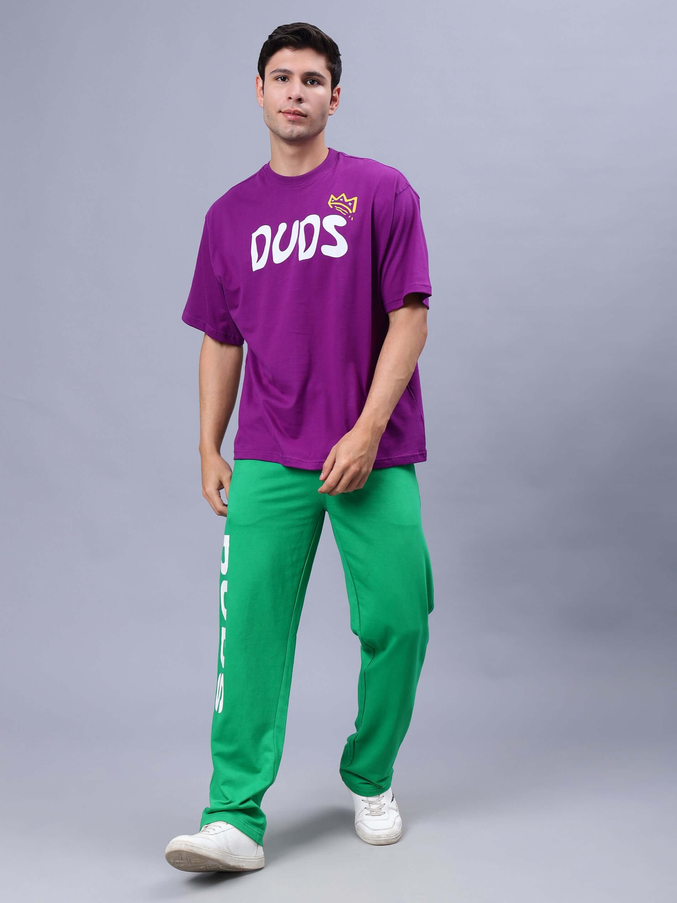 Model wearing MAKE MONEY NOT FRIENDS OVER-SIZED T-SHIRT PURPLE with green pants.