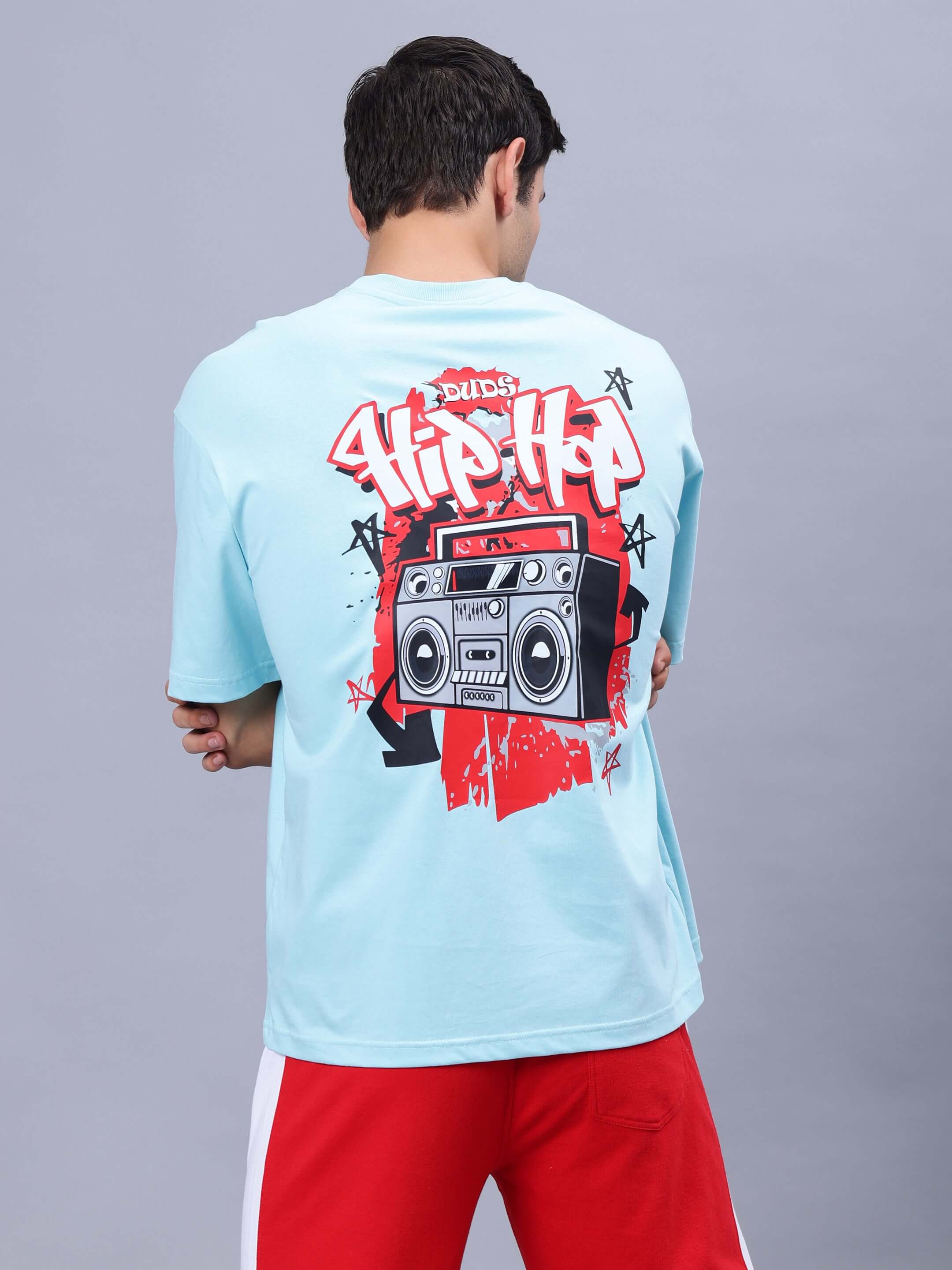 Men wearing RADIO OVER-SIZED T-SHIRT SKY BLUE with hip hop boombox graphic on back, casual fit.