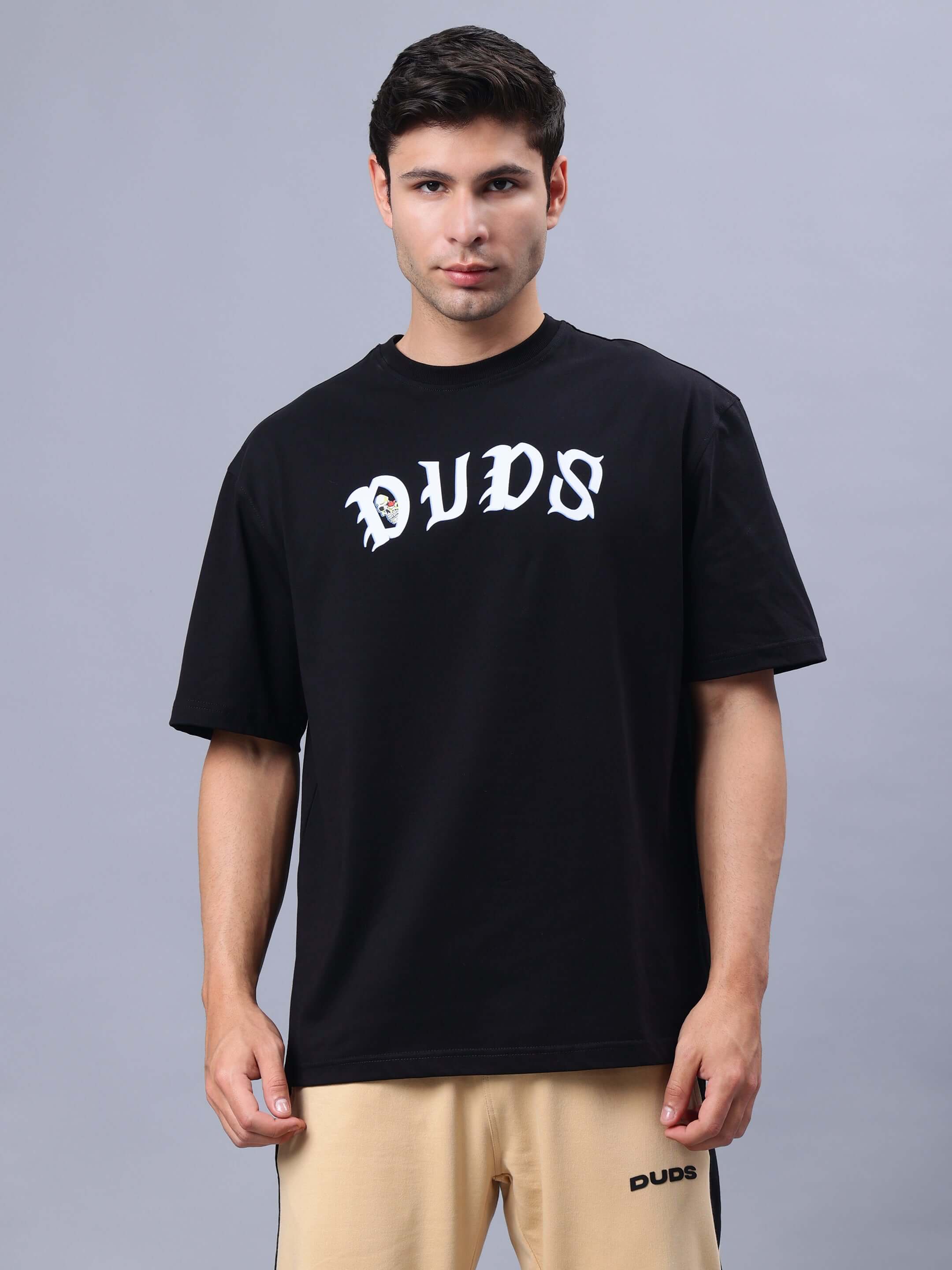 Model wearing REBELS WTF OVER-SIZED T-SHIRT BLACK by DUDS, showcasing the front design.