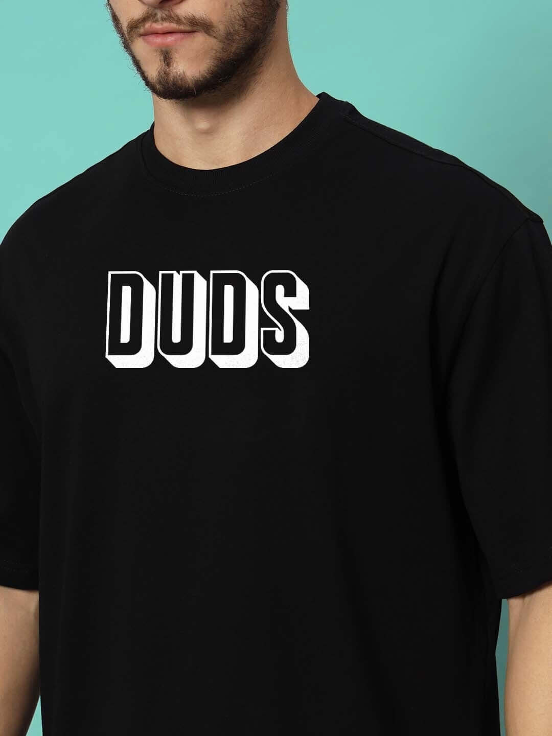 Alt Tag: Person wearing DUDS PANTHER OVER-SIZED T-SHIRT BLACK with bold DUDS logo in front.