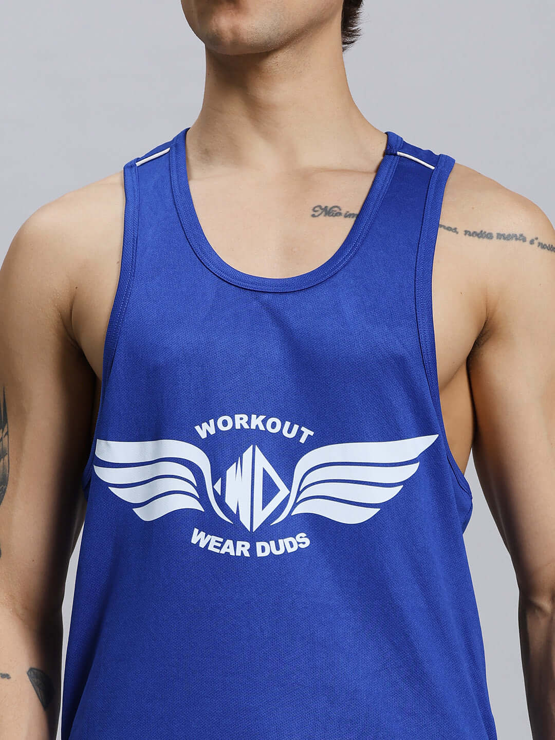 Alt Tag: Person wearing a royal blue gym tank top with "Workout Wear Duds" and wing logo, showcasing athletic fit and style.
