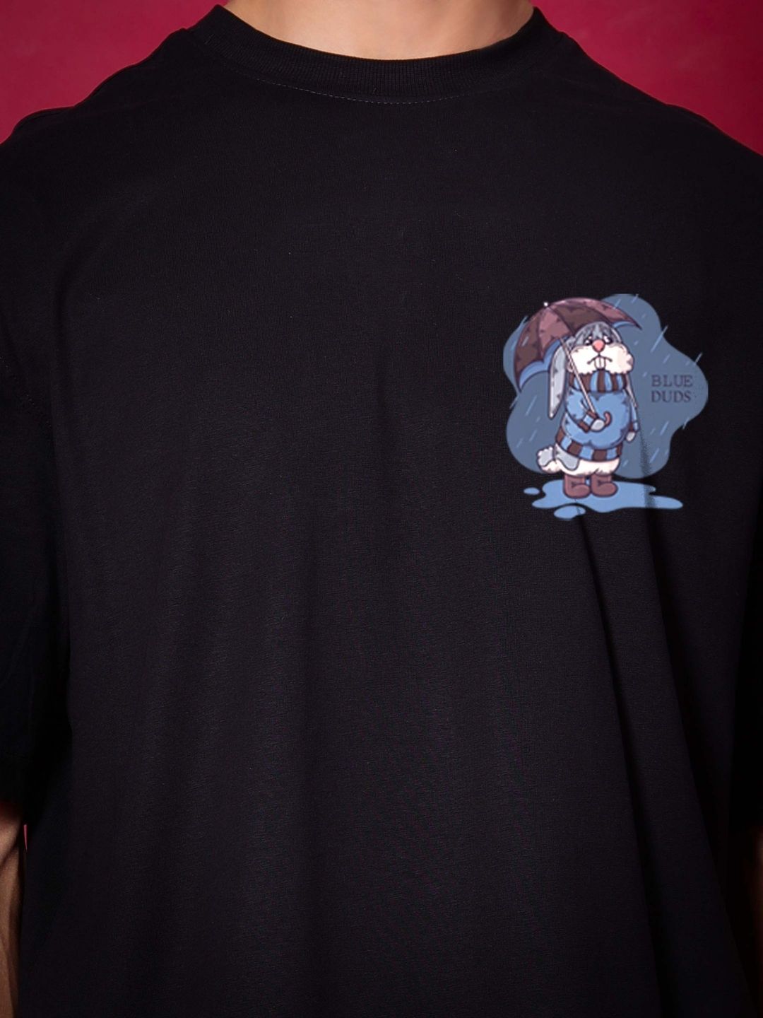 Man wearing BLUE LAPIN OVER-SIZED T-SHIRT BLACK with cute rabbit design, made from premium heavy gauge fabric, 97% cotton, and 3% elastane.