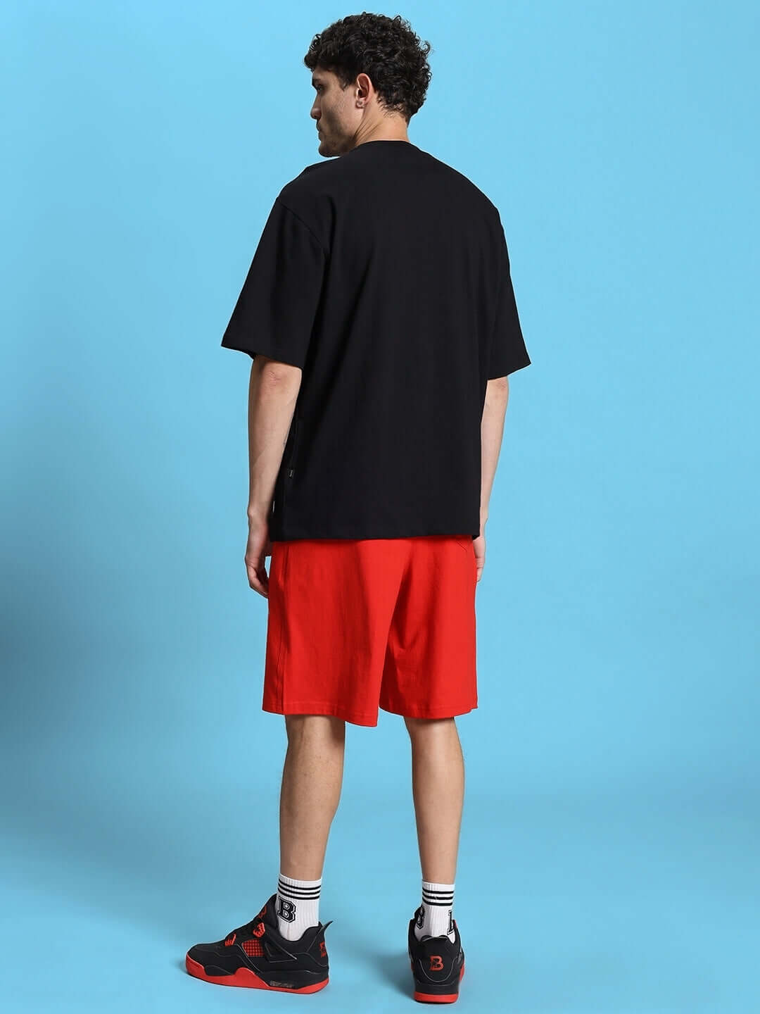 Back view of a man wearing a black T-shirt and red shorts from the ACRO SUMMER CO-ORD SET, perfect for casual summer style.