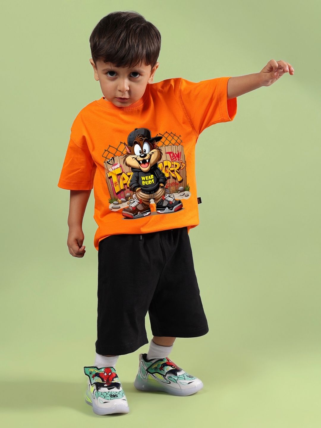 Child wearing Crazy Rapper co-ord set in orange and black, featuring hip-hop street-style fashion for boys and girls with cartoon print.