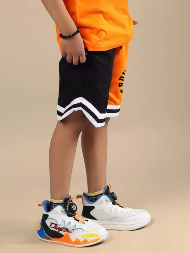 Boy wearing black-orange track and field shorts from DUDS, showcasing athletic style and comfort, available for custom sizing.
