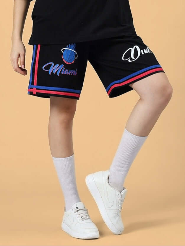 Model wearing black women's Miami regular fit shorts with blue and red accents