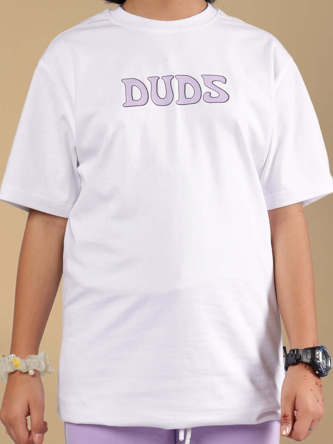 Child wearing a white Knight Ryder t-shirt from DUDS, featuring purple lettering on the front.