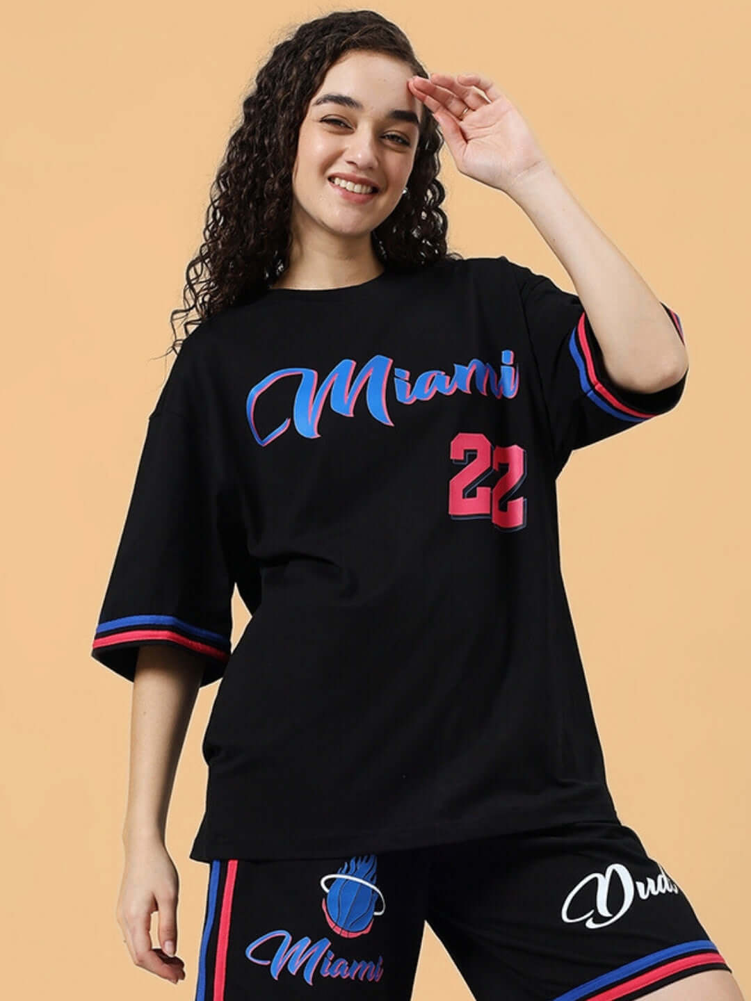Model wearing oversized black Miami t-shirt in heavy gauge fabric with vibrant red and blue accents, perfect casual wear.