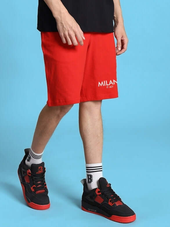Man wearing ACRO Summer Shorts in red, paired with black sneakers. Stylish summer outfit option, available in custom fit for prepaid orders.