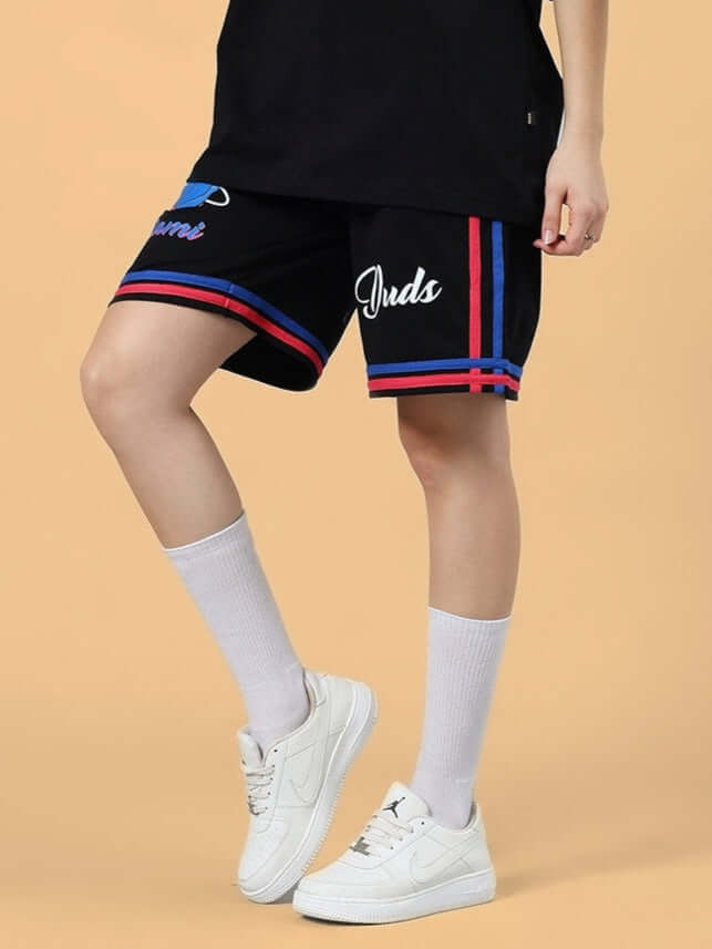 Women's Miami Regular Fit Black Shorts with Custom Fit Option, featuring red and blue stripes, worn with white sneakers and socks.