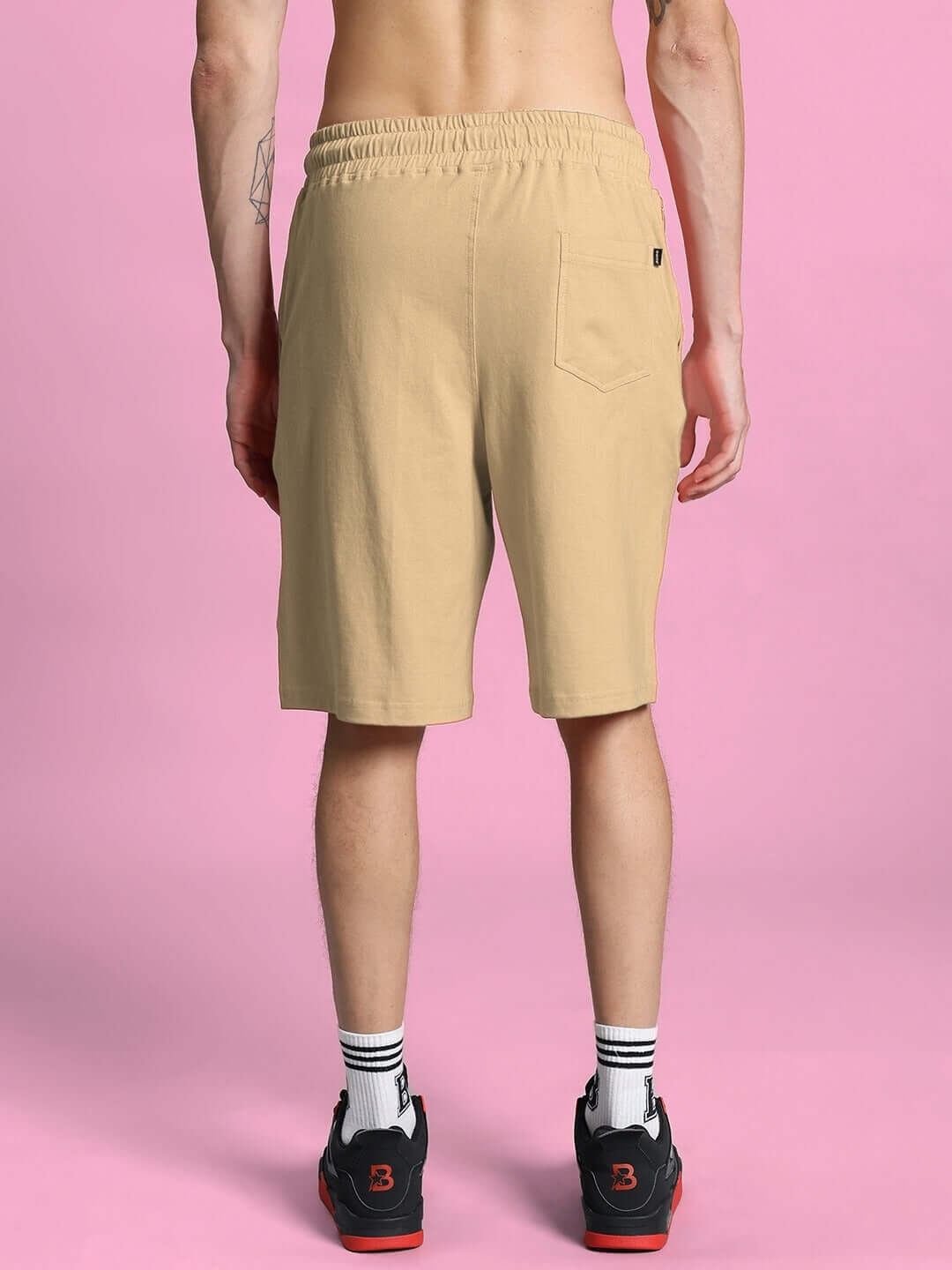Back view of MAGIC CITY SUMMER CO-ORD SET shorts in beige, featuring premium cotton fabric and elastic waistband, against pink backdrop.