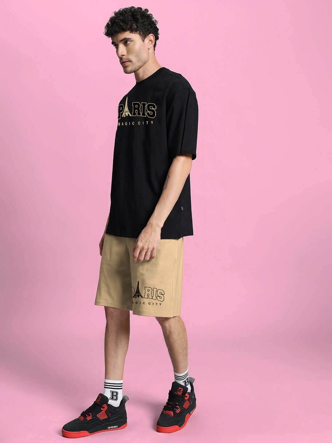 Man wearing MAGIC CITY SUMMER CO-ORD SET in black and beige against a pink background, featuring premium cotton fabric and stylish design.