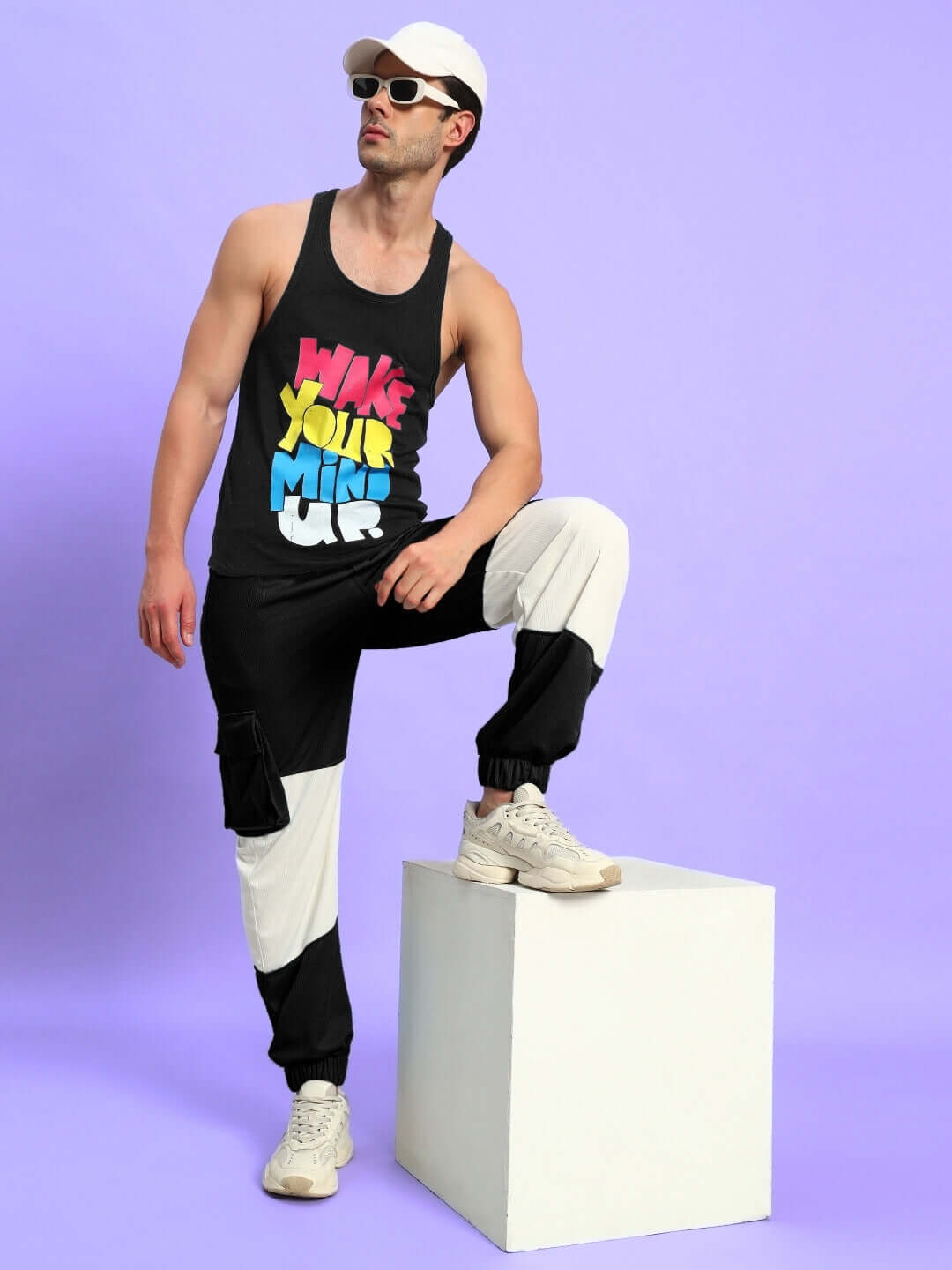 Model wearing Radiant Relaxed Fit Joggers in black and white, styled with a colorful tank top and white sneakers.