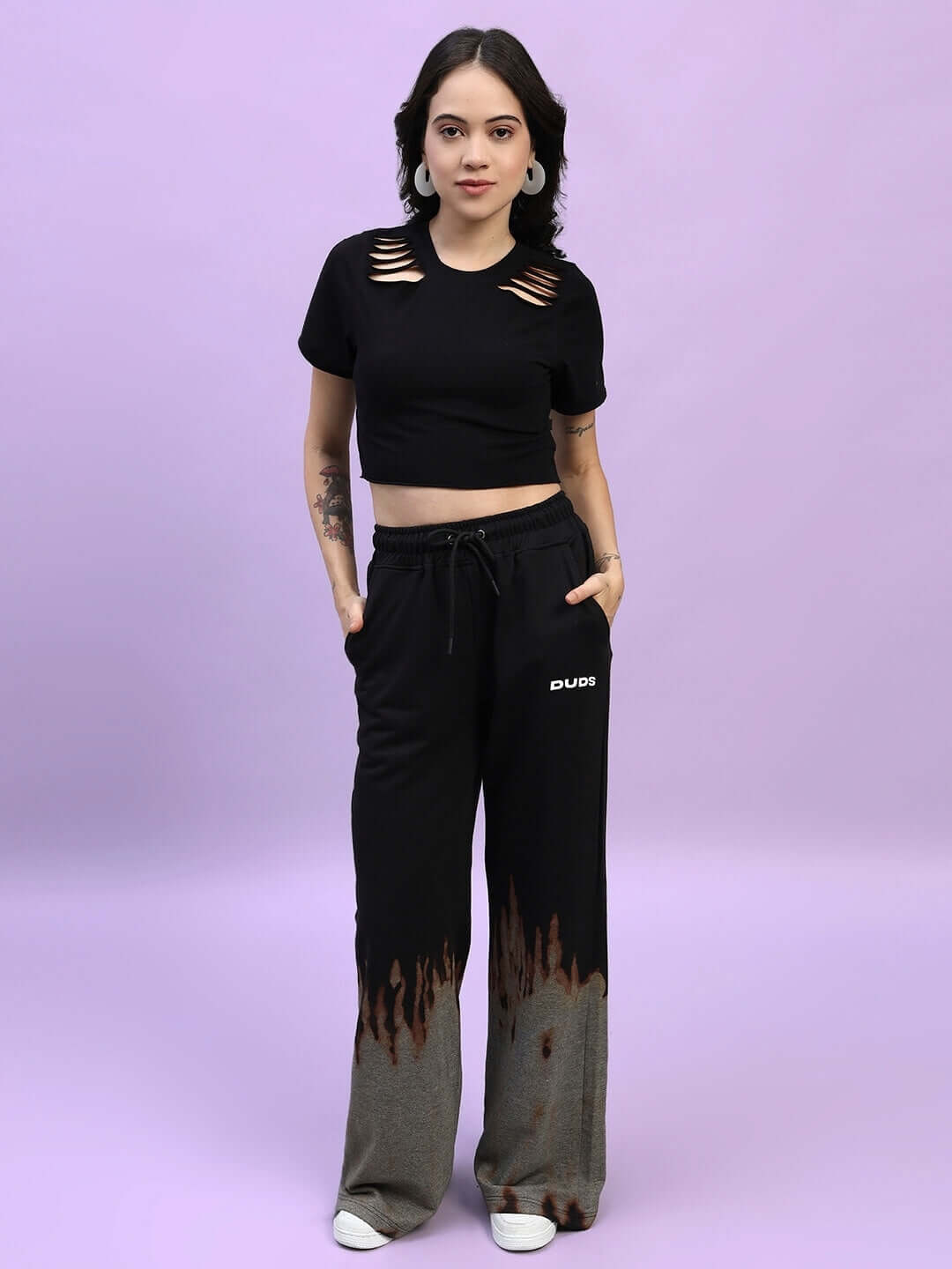 Model wearing Women's Fire Flame Baggy Tie-Dye Jogger in black by DUDS, showcasing unique flame design and custom fit option.