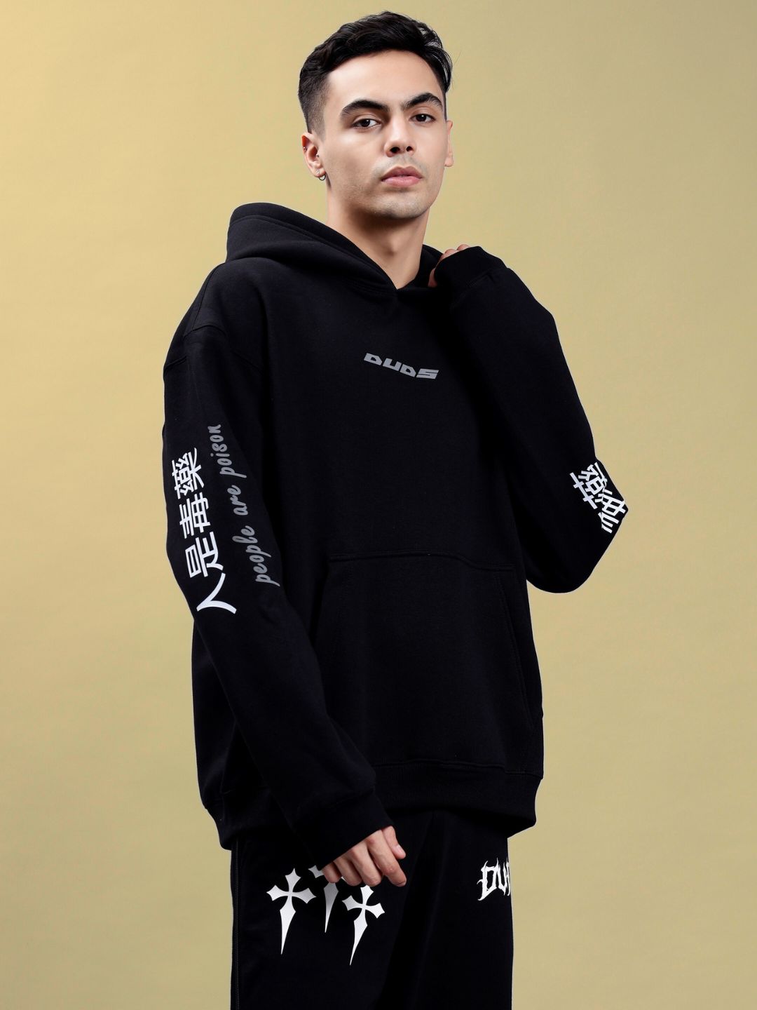 Model wearing POISON SKULL REFLECTOR OVERSIZE HOODIE BLACK, front view, showcasing stylish design on sleeves and chest.