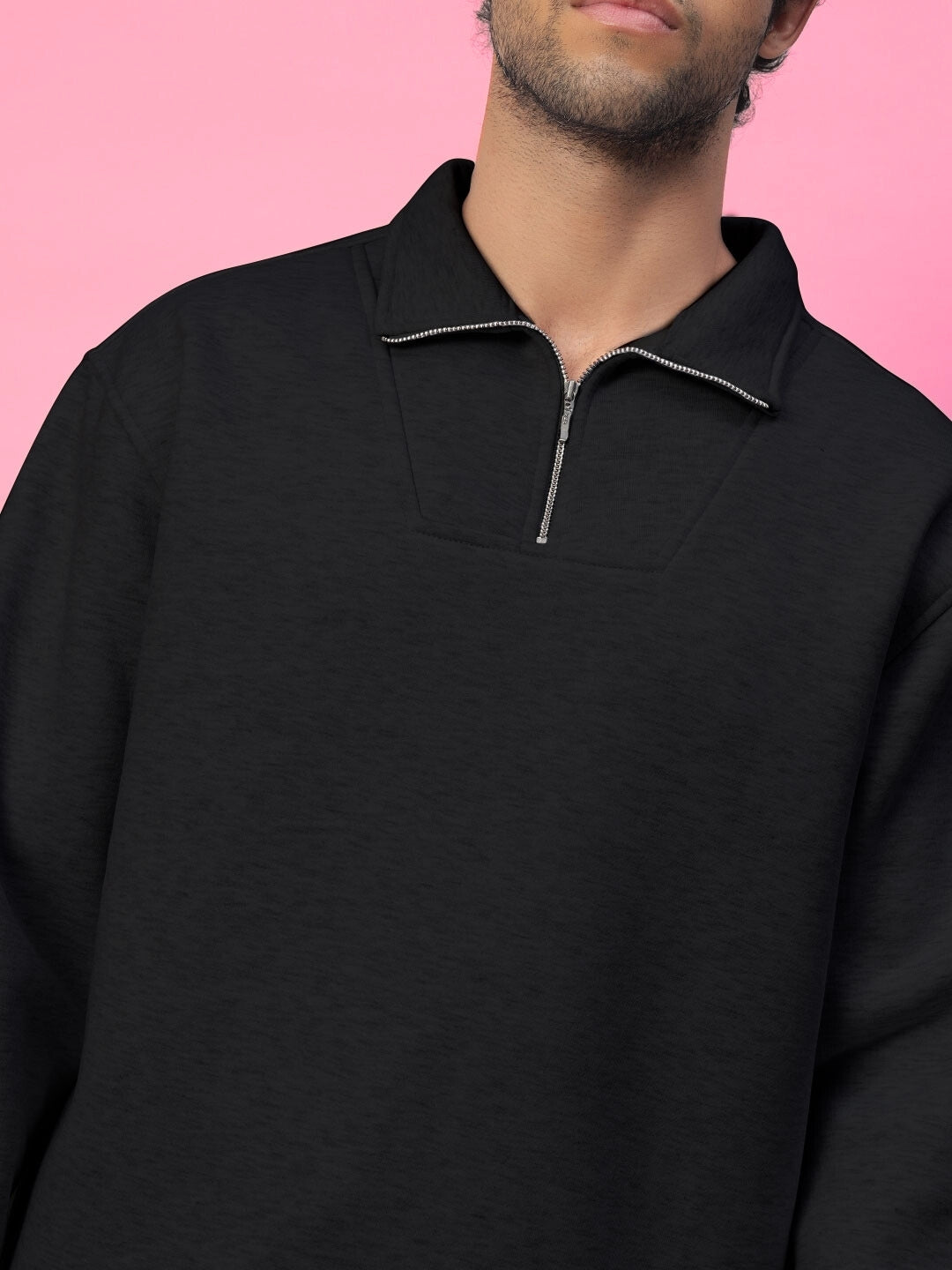 Model wearing black cotton fleece sweatshirt with zipper, BONA-FIDE fashion on pink background.