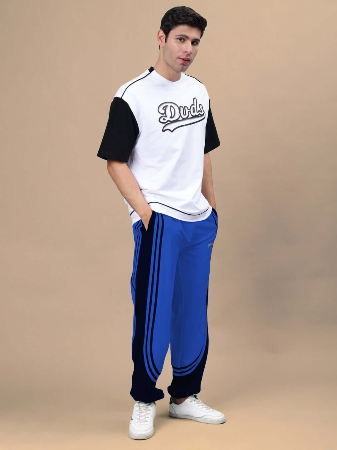 Model wearing Frenzy Curve Contrast Joggers in blue and black, styled with a Duds shirt, showcasing casual urban fashion.