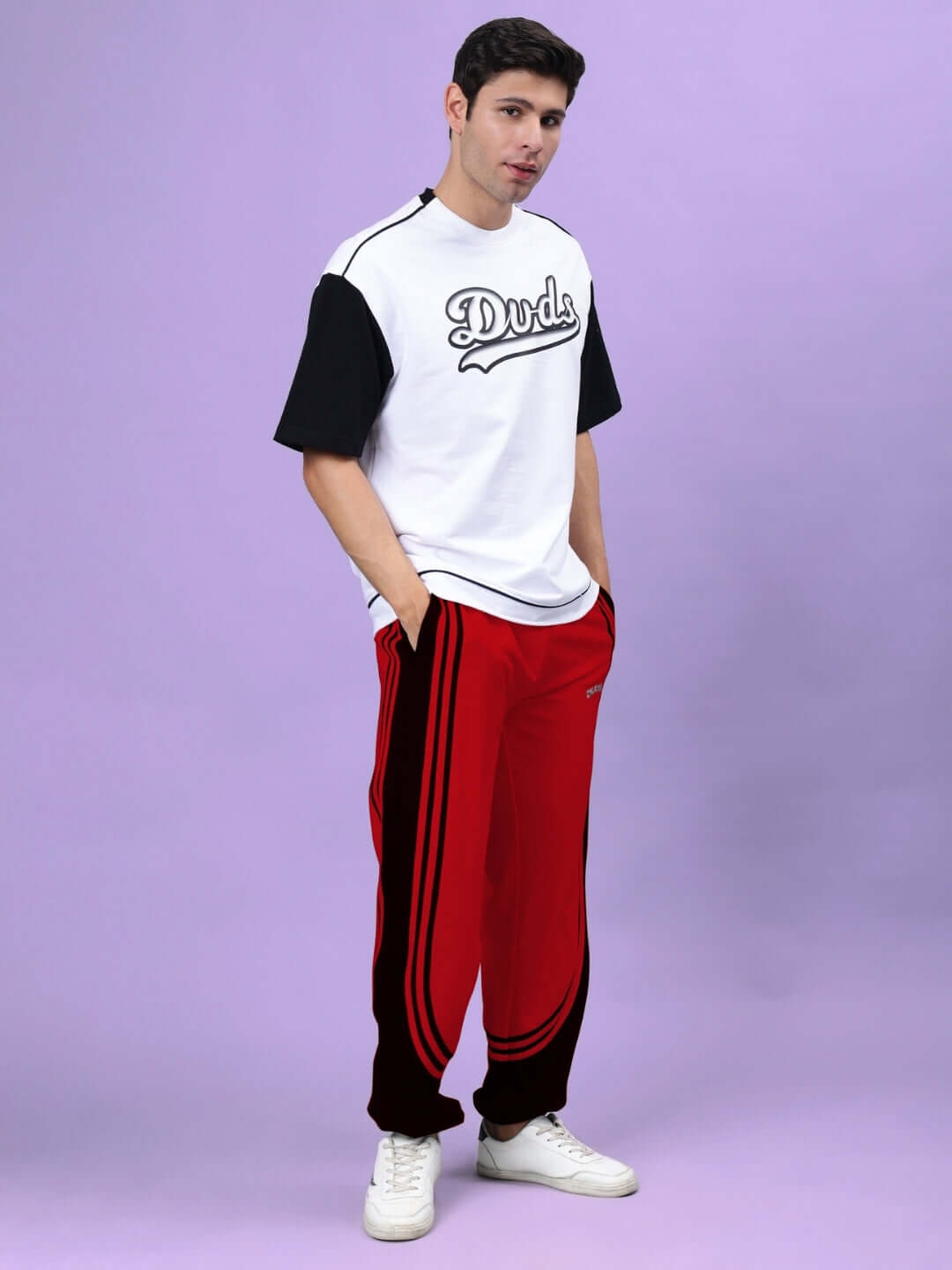 Model wearing red and black Frenzy Curve Contrast Joggers by DUDS against a purple background.