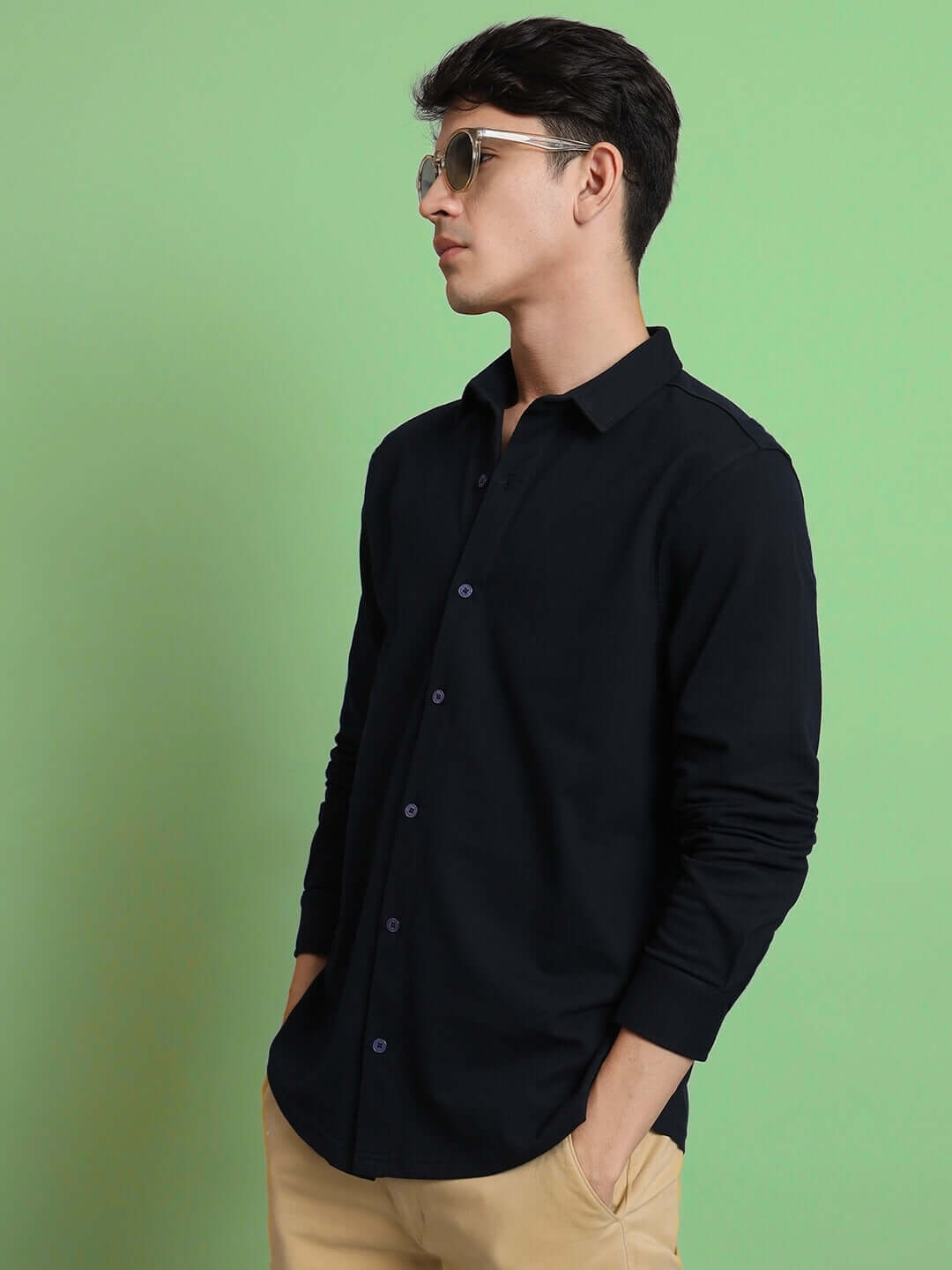 Model wearing a navy blue sporty pique shirt with full sleeves, wrinkle-free and slim fit design, ideal for all-day comfort.