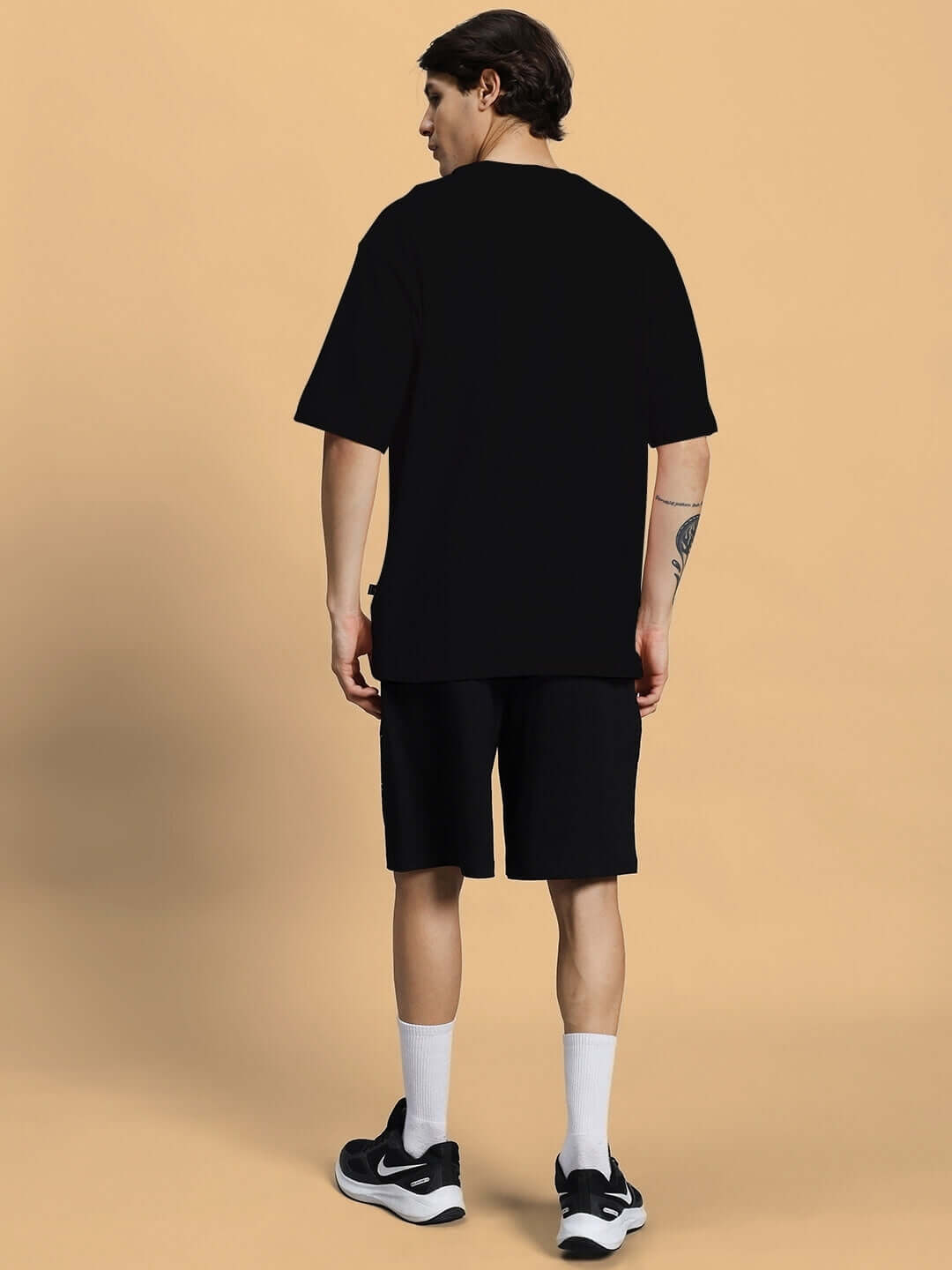 Model wearing black summer co-ord set with premium cotton fabric, featuring t-shirt and shorts. Ideal for casual style. Made in India.
