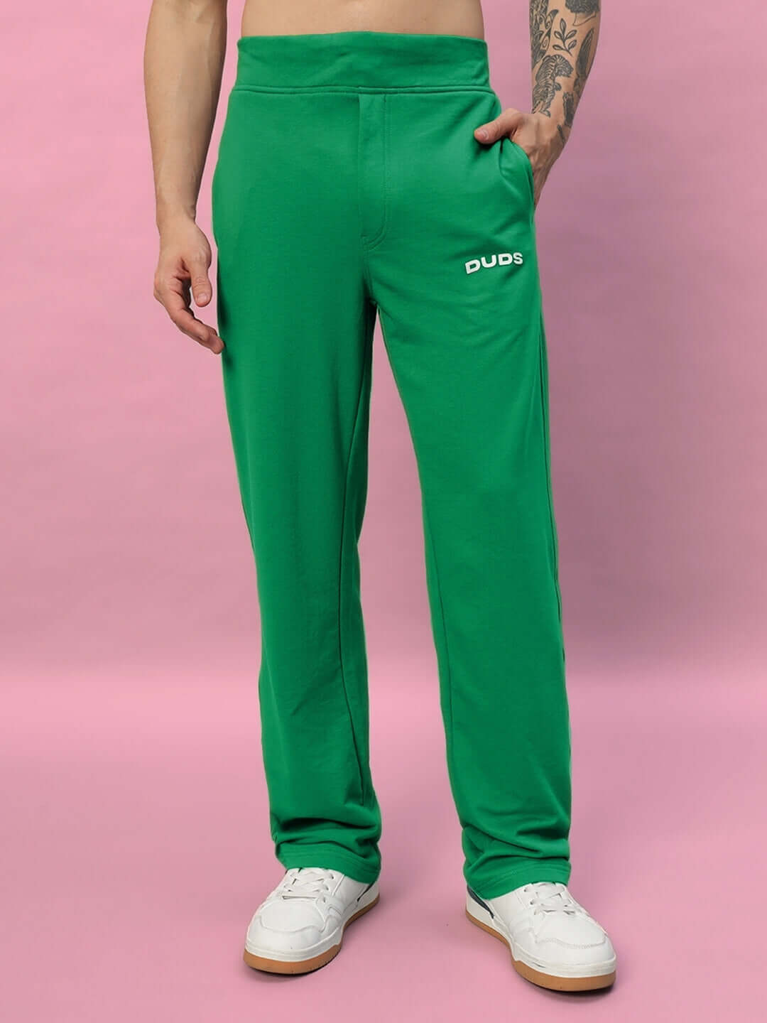 Green NEW ERA RELAXED FIT JOGGERS by DUDS, with personalized sizing option, displayed on a pink backdrop.
