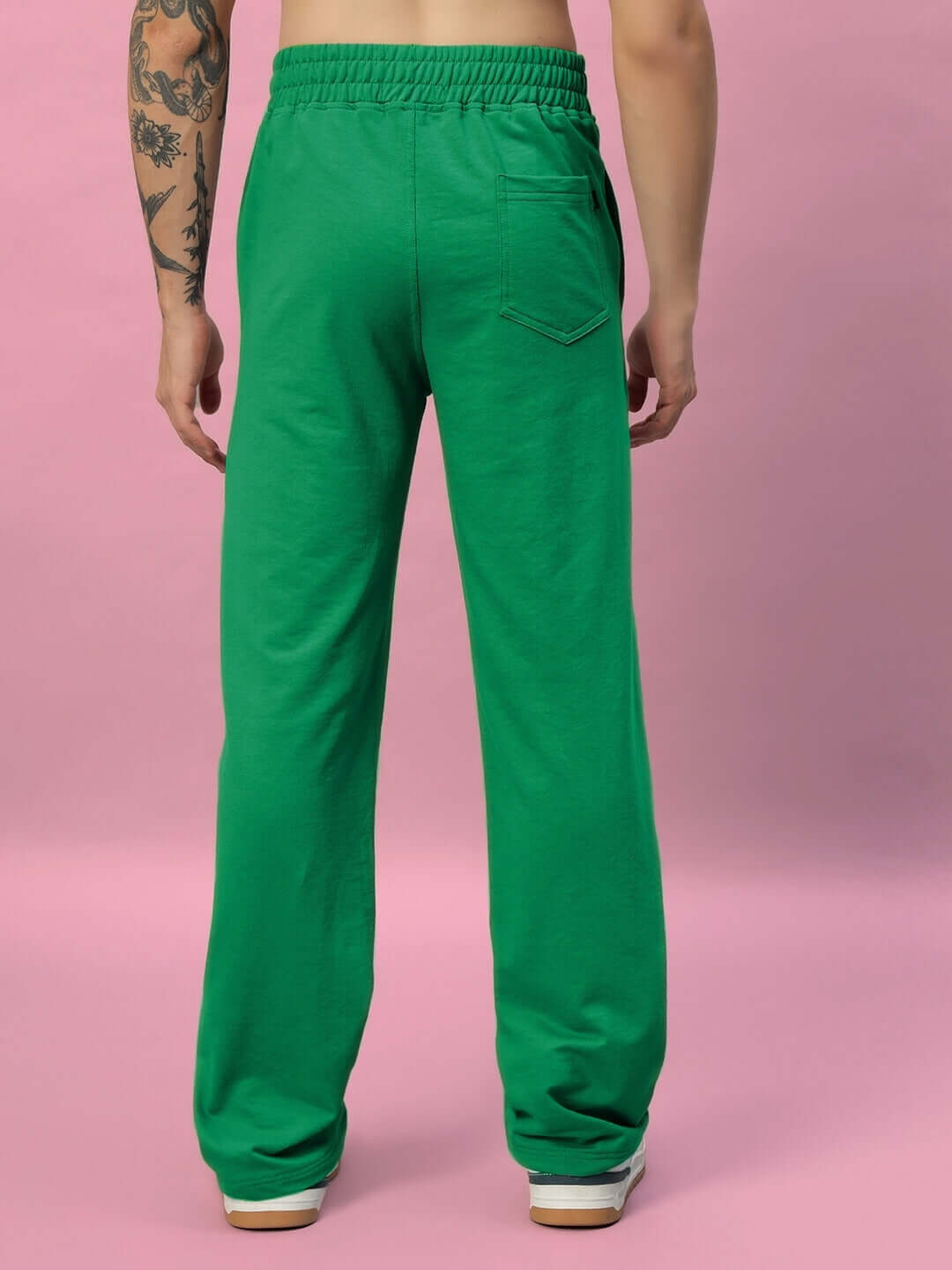 Back view of green New Era Relaxed Fit Joggers, showcasing comfortable design and stylish fit on a pink background.