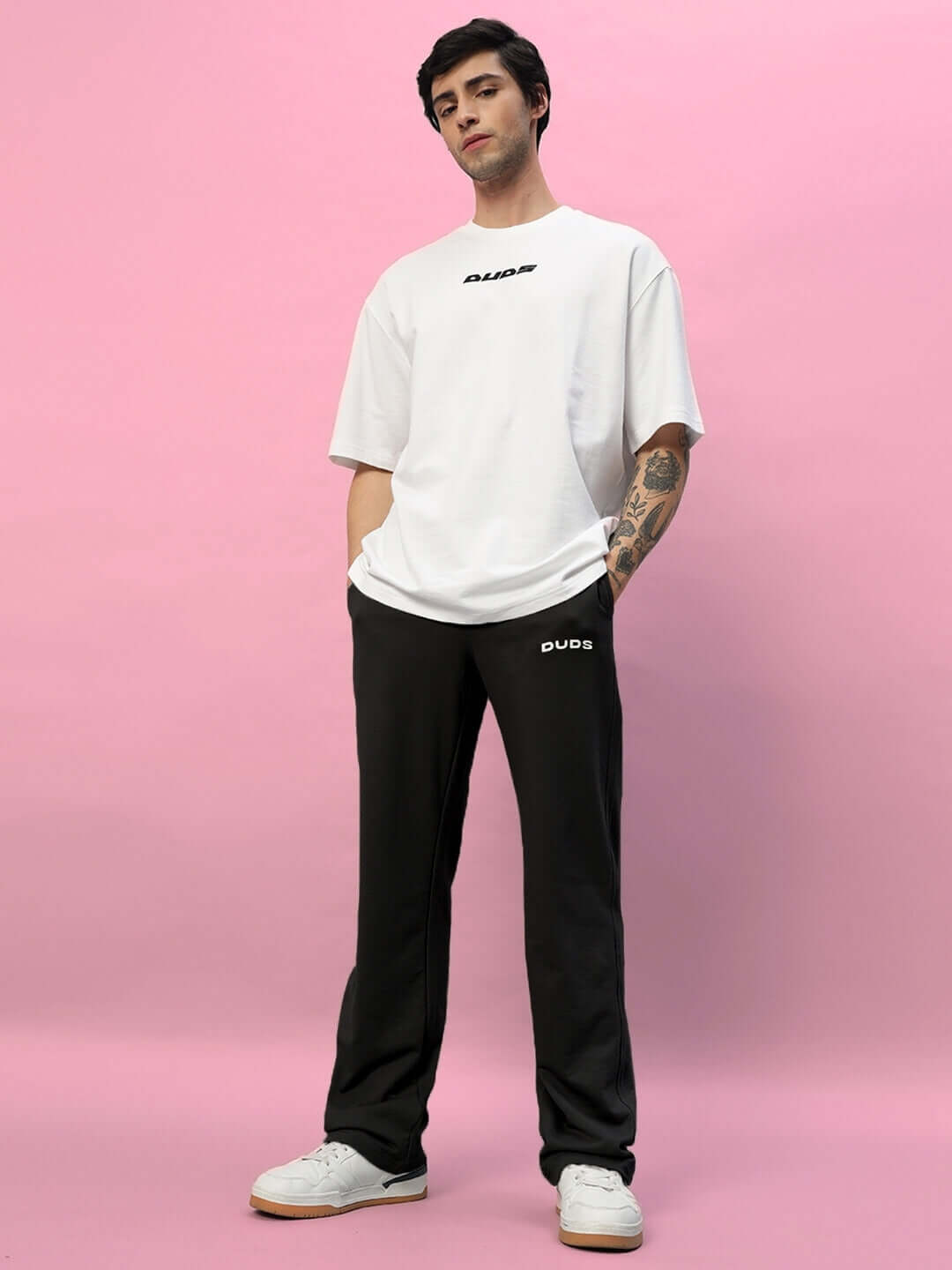 Model wearing New Era Relaxed Fit Joggers in black by DUDS, featuring a comfortable fit, styled with a casual white t-shirt.