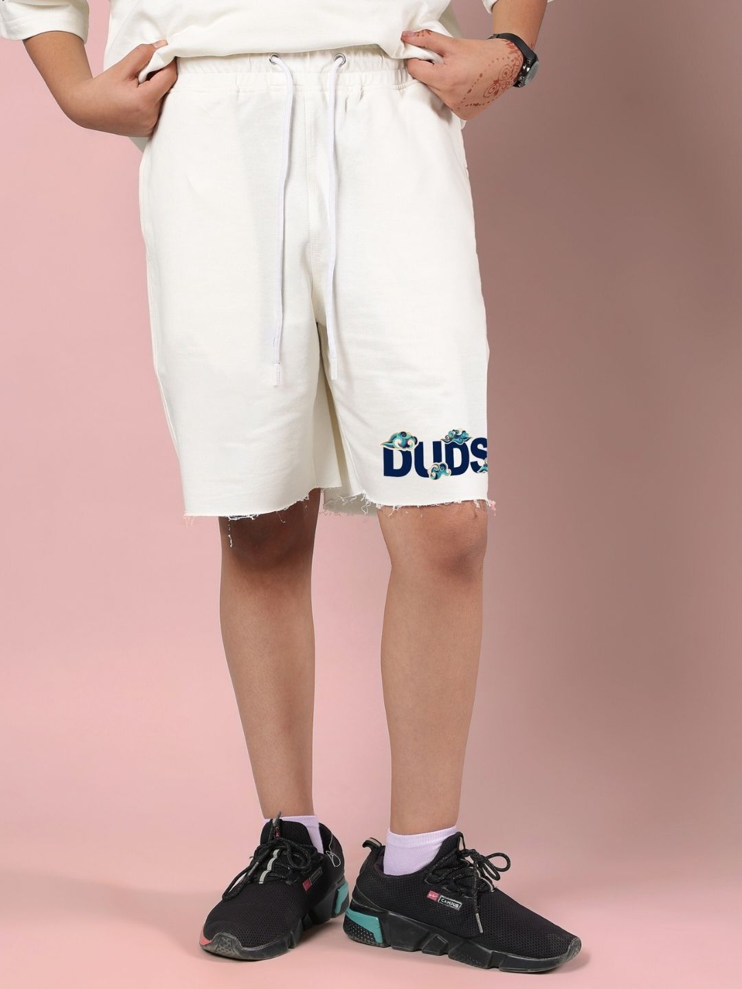 Child wearing CLOUD PRINTED CO-ORD FOR BOYS AND GIRLS OFF WHITE shorts with design detail on pink background