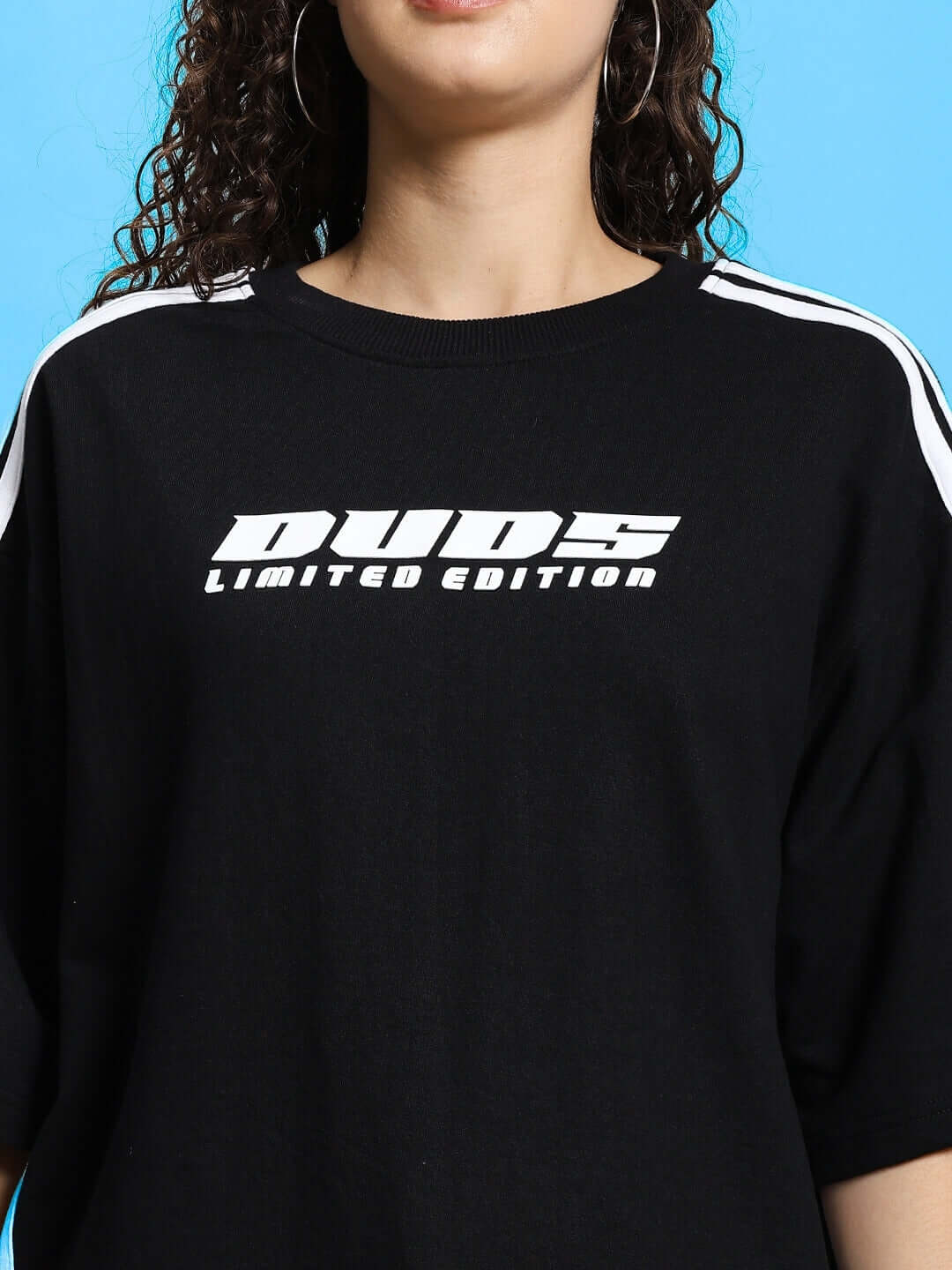 WOMEN'S RODDY OVER-SIZED CLASSIC T-SHIRT BLACK with 'DUDS LIMITED EDITION' print, modeled against blue background.