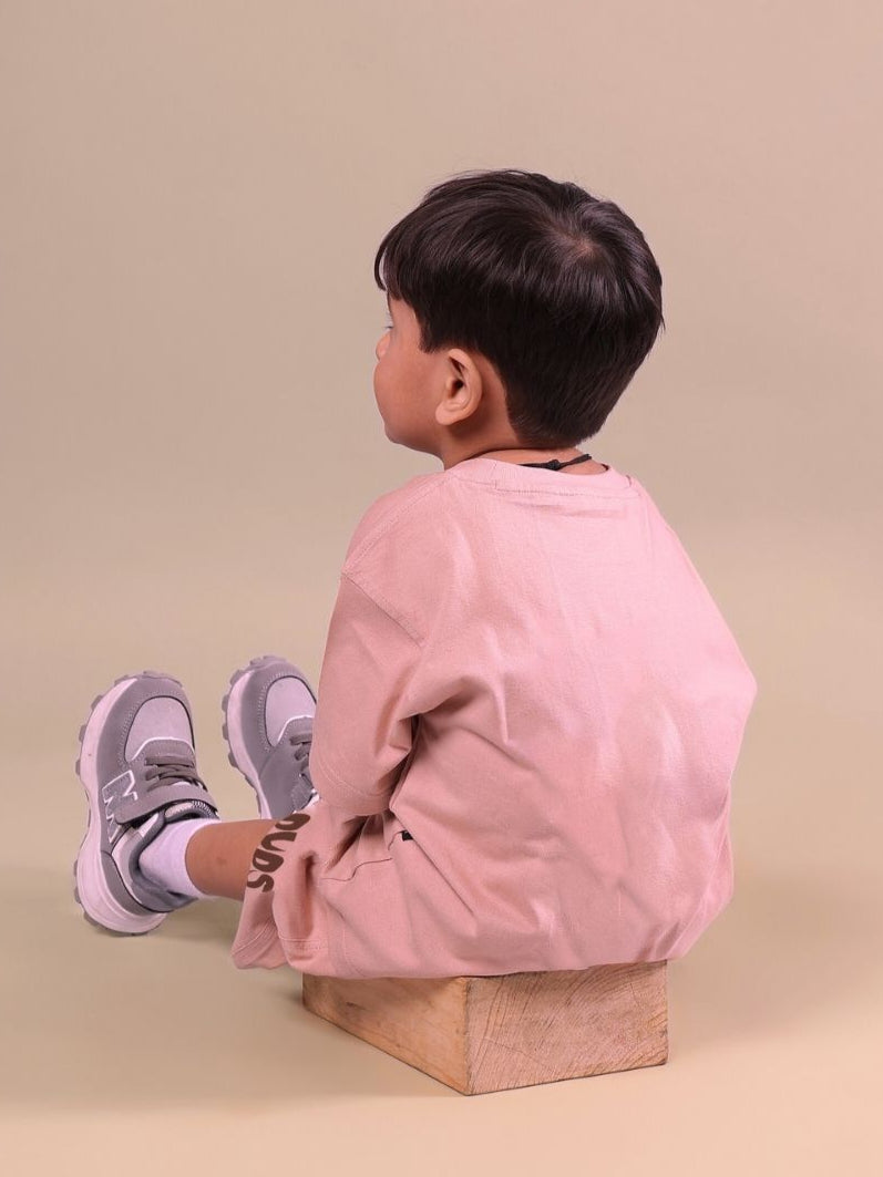 Child wearing Flint Bunny beige unisex t-shirt sitting on block, side view