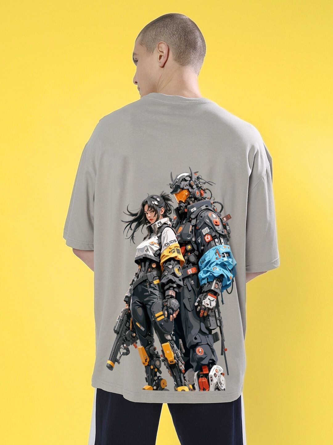 Man wearing CYBERPUNK OVER-SIZED T-SHIRT GREY with futuristic graphic design on yellow background
