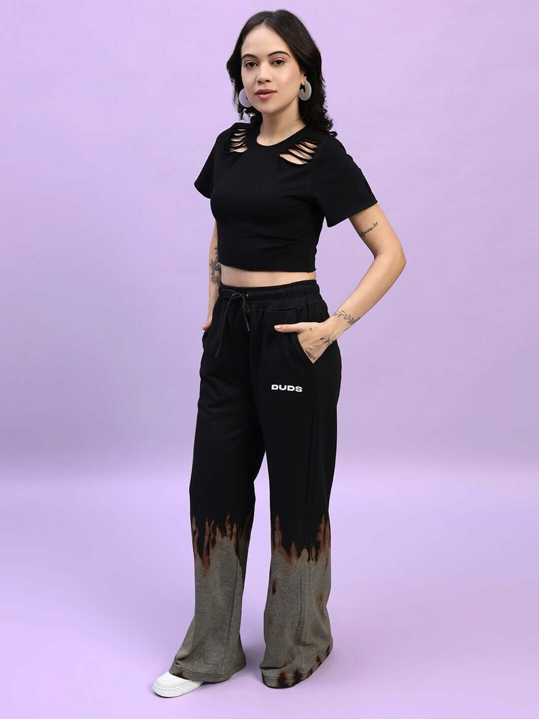 Woman wearing a black fire flame baggy tie-dye co-ord set, featuring premium cotton and elastane with a trendy cutout top and joggers.