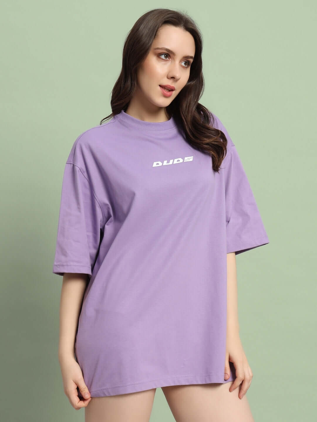 Model wearing women's lavender oversized t-shirt by DUDS, showcasing relaxed fit and style.