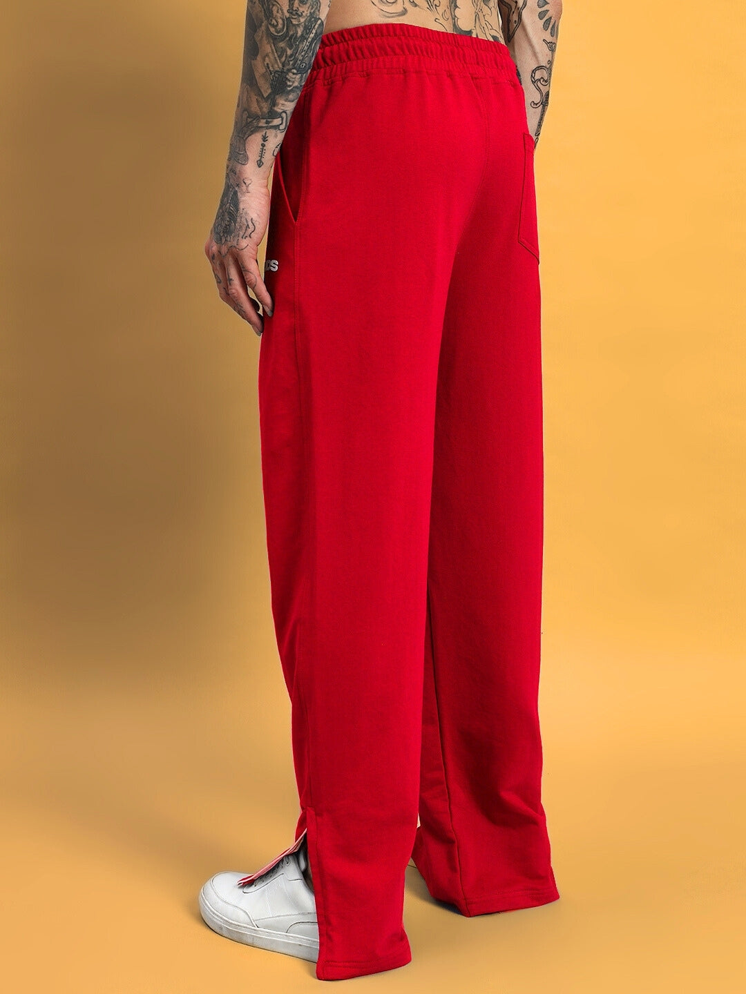 Model wearing red Hershey side slit joggers by DUDS, showcasing comfortable style with customizable fit options.